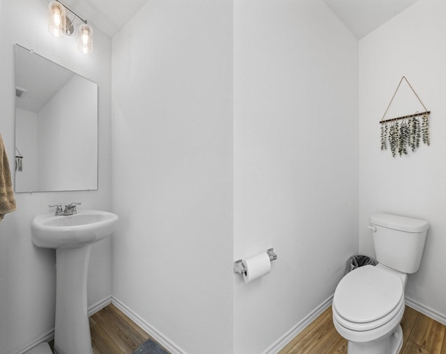 bathroom with hardwood / wood-style flooring, toilet, and sink