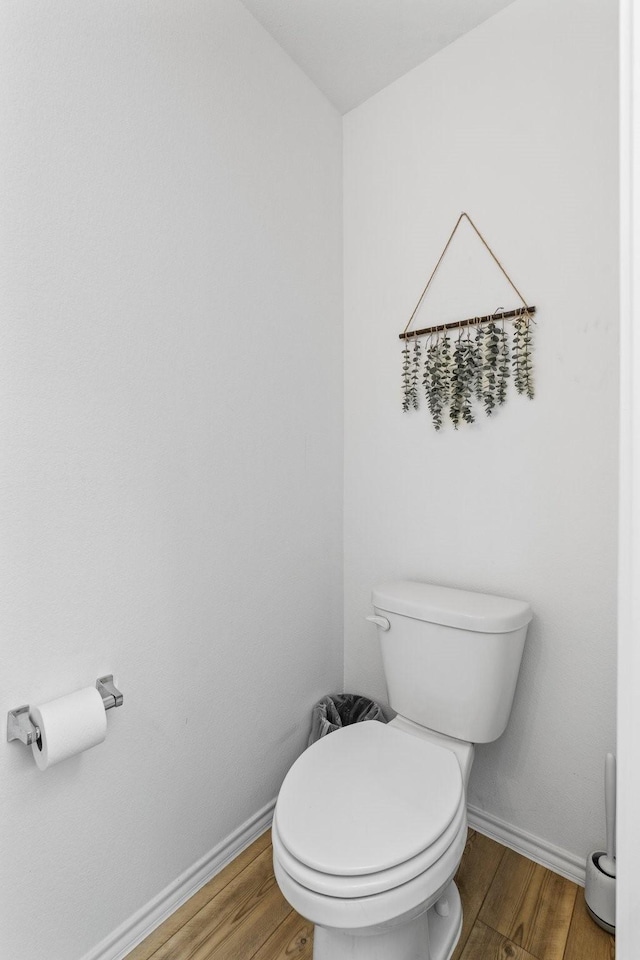 bathroom with hardwood / wood-style flooring and toilet