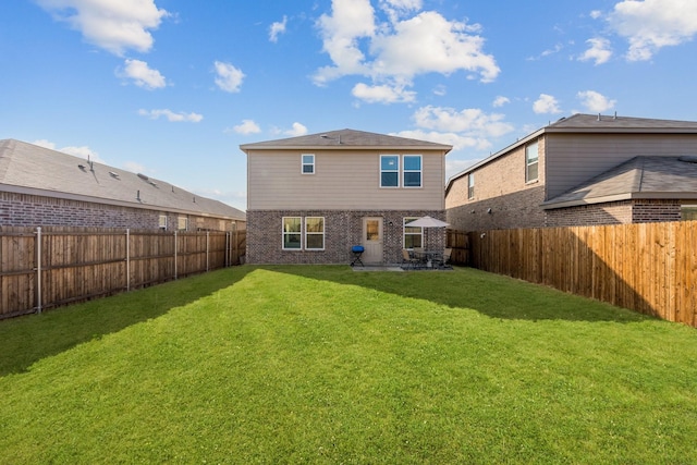 rear view of house featuring a yard and a patio area