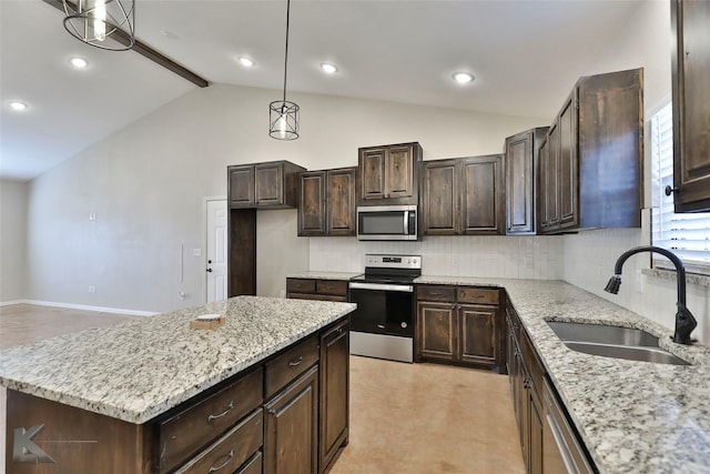 kitchen with sink, light stone counters, a center island, hanging light fixtures, and appliances with stainless steel finishes