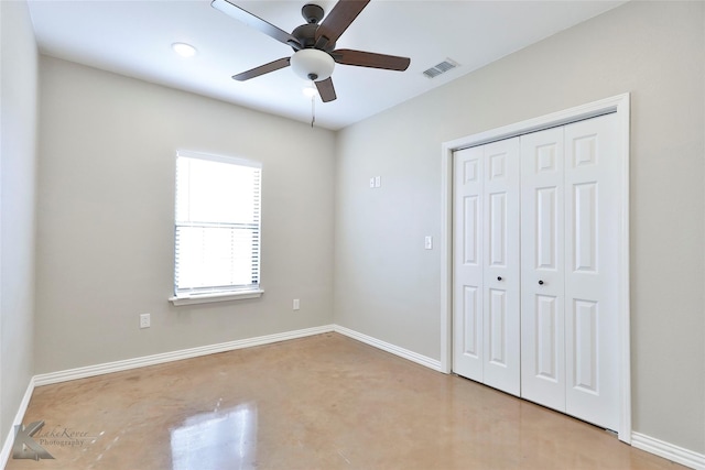 unfurnished bedroom featuring concrete flooring, a closet, and ceiling fan