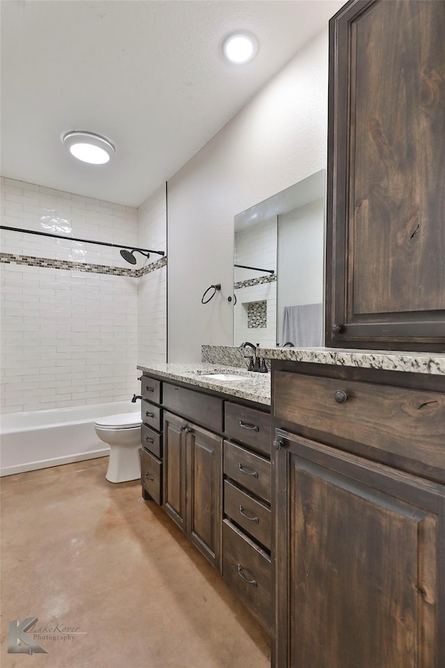 full bathroom with vanity, tiled shower / bath, concrete flooring, and toilet