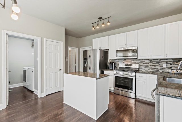 kitchen featuring stainless steel appliances, a center island, white cabinets, and independent washer and dryer