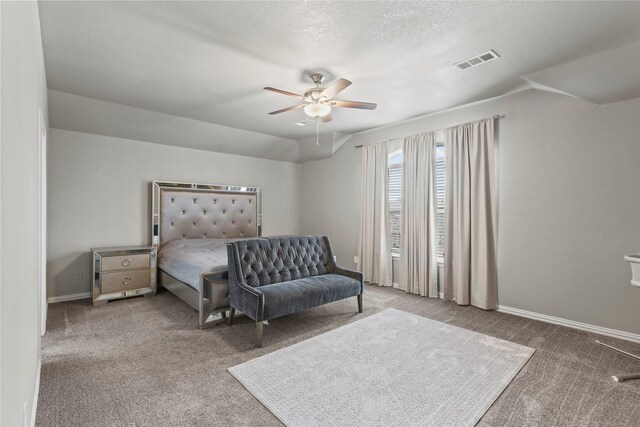 carpeted bedroom with vaulted ceiling, a textured ceiling, and ceiling fan