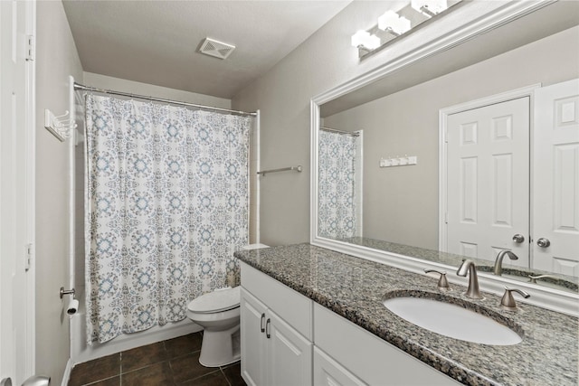 bathroom with tile patterned flooring, vanity, and toilet