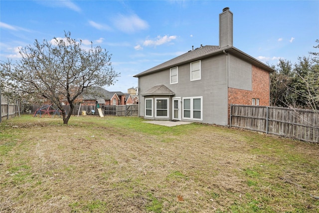 rear view of property with a yard, a playground, and a patio area