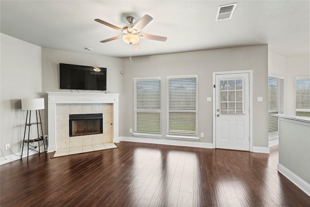 unfurnished living room featuring hardwood / wood-style flooring, a tile fireplace, and ceiling fan