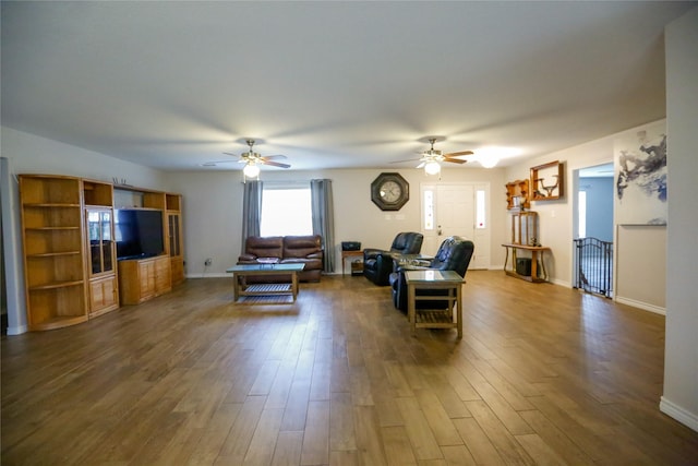 living room with dark wood-type flooring and ceiling fan