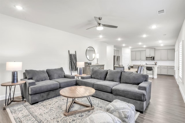 living room featuring light hardwood / wood-style floors and ceiling fan