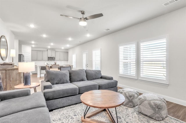 living room with hardwood / wood-style flooring and ceiling fan