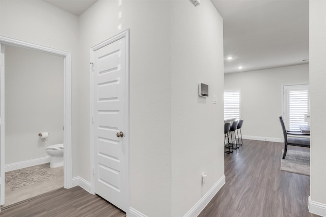 corridor with hardwood / wood-style flooring