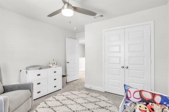 bedroom featuring light colored carpet, a closet, and ceiling fan