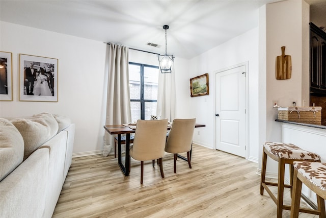 dining area featuring an inviting chandelier and light hardwood / wood-style flooring