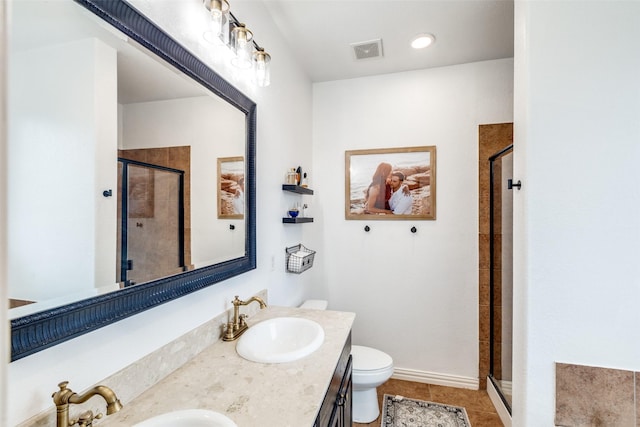 bathroom with toilet, vanity, tile patterned floors, and a shower with shower door