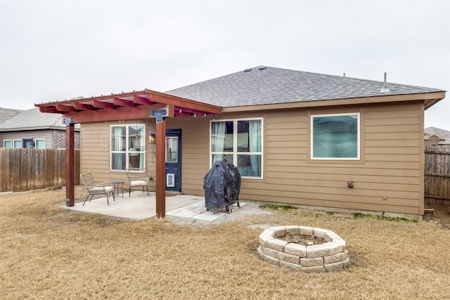 back of property featuring a yard, a patio area, and an outdoor fire pit