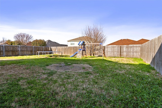 view of yard featuring a playground and a trampoline