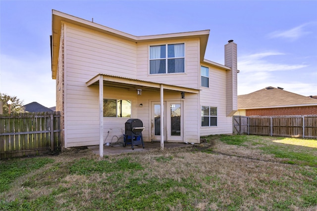 rear view of property with a yard and a patio