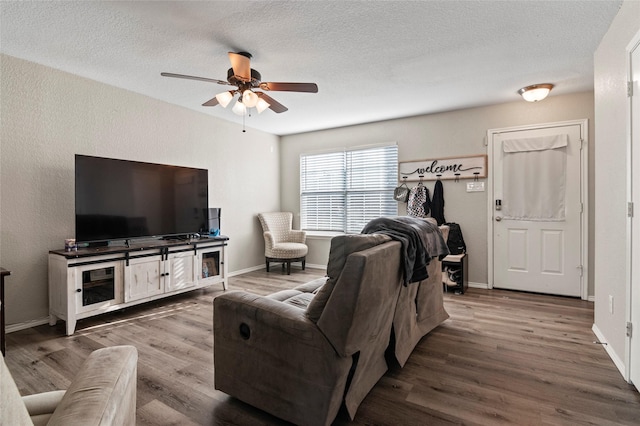 living room with hardwood / wood-style floors, a textured ceiling, and ceiling fan