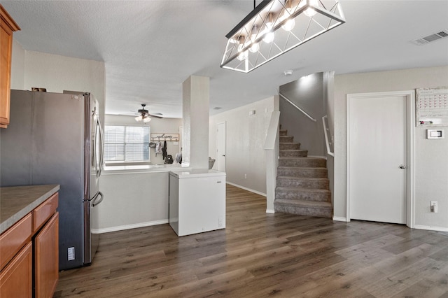 kitchen with pendant lighting, dark hardwood / wood-style floors, stainless steel refrigerator, and ceiling fan