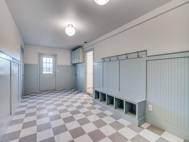 mudroom with light floors, wainscoting, and visible vents