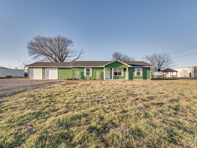 single story home featuring driveway, a front lawn, and an attached garage