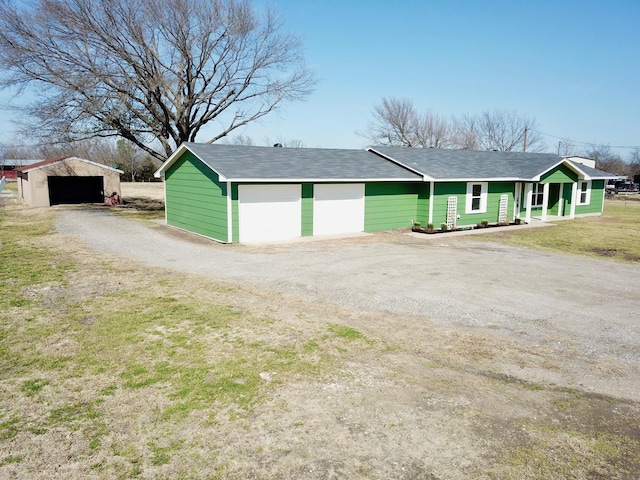 view of front of house featuring a detached garage and dirt driveway