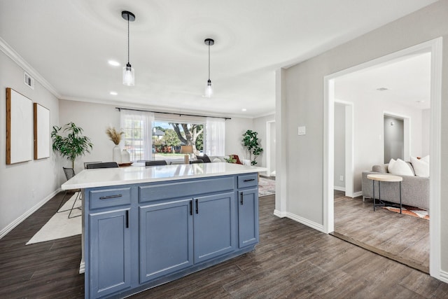 kitchen featuring crown molding, dark wood-type flooring, blue cabinetry, and pendant lighting