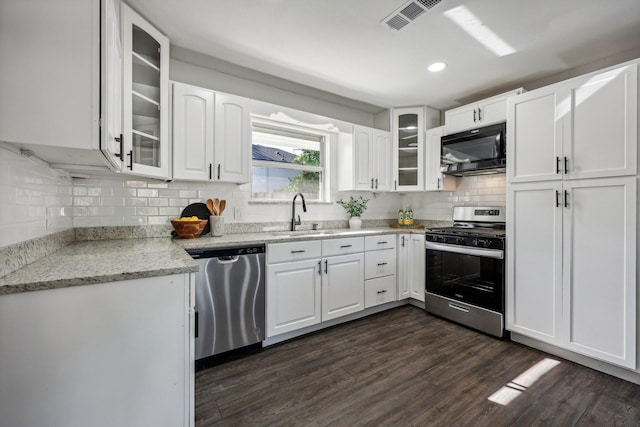 kitchen featuring visible vents, appliances with stainless steel finishes, dark wood-type flooring, white cabinetry, and a sink