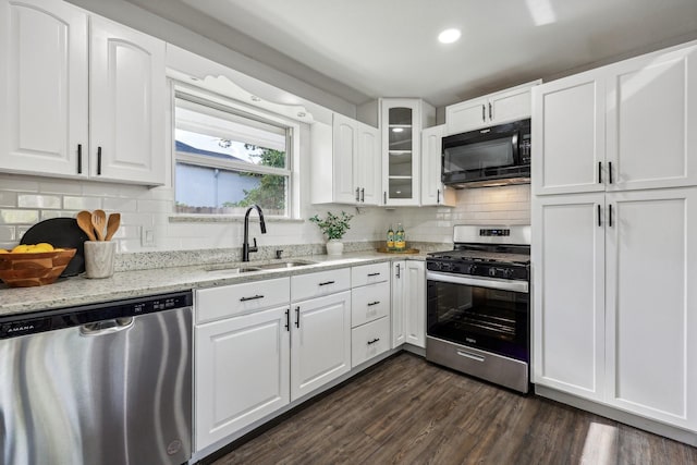 kitchen featuring dark wood-style floors, white cabinetry, stainless steel appliances, and a sink