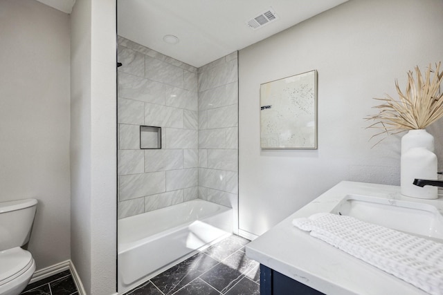 bathroom featuring toilet, vanity, visible vents, baseboards, and washtub / shower combination