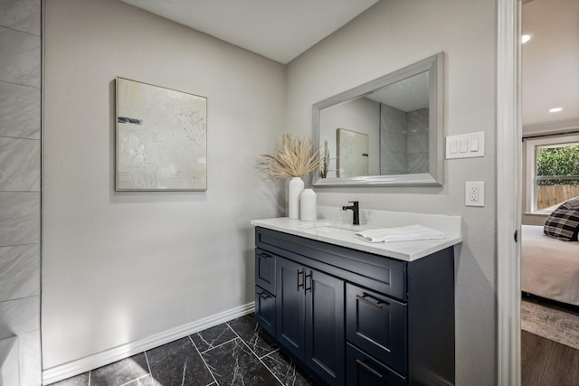 full bathroom with marble finish floor, vanity, and baseboards