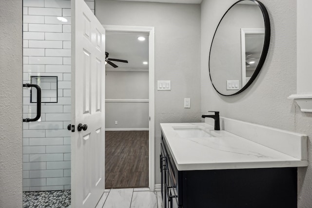 full bathroom with a shower stall, wood finished floors, a ceiling fan, and vanity