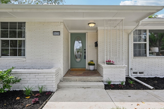 property entrance with crawl space and brick siding