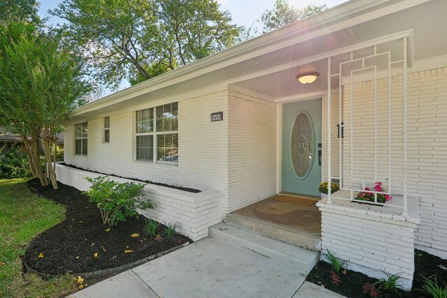 view of exterior entry with brick siding