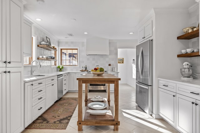 kitchen with sink, appliances with stainless steel finishes, white cabinetry, ornamental molding, and decorative backsplash