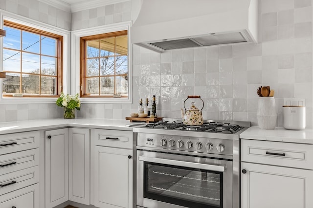 kitchen featuring premium range hood, stainless steel gas range, and white cabinets