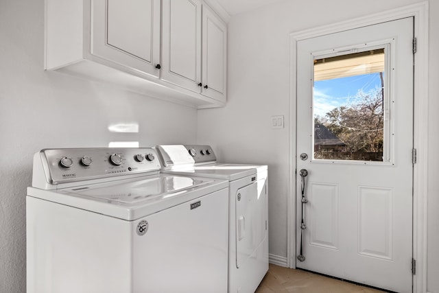 laundry area with cabinets and washing machine and clothes dryer