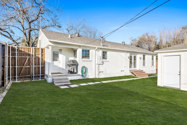 back of property featuring a lawn and a shed