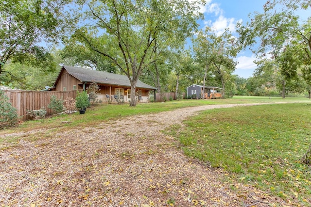 view of yard featuring an outbuilding and fence