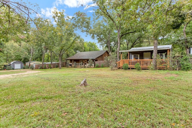 view of yard featuring an outbuilding, a deck, and a storage shed