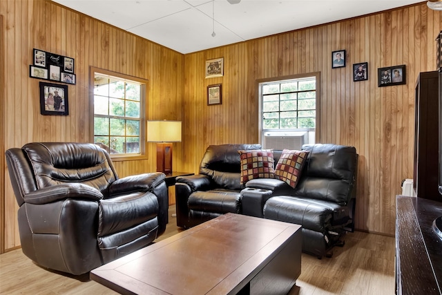 living room featuring light wood-style floors, cooling unit, and wood walls