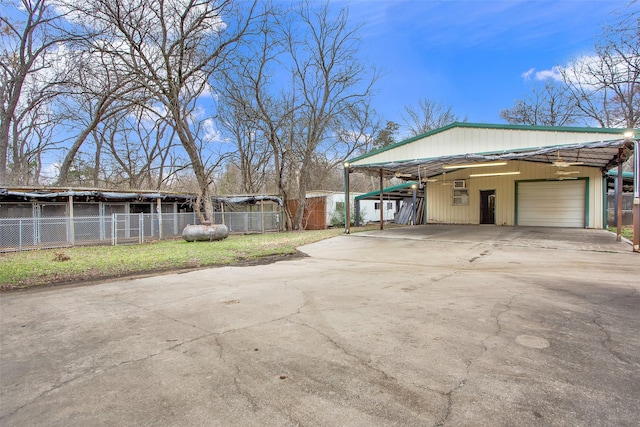 view of property exterior with a detached garage, fence, and an outdoor structure
