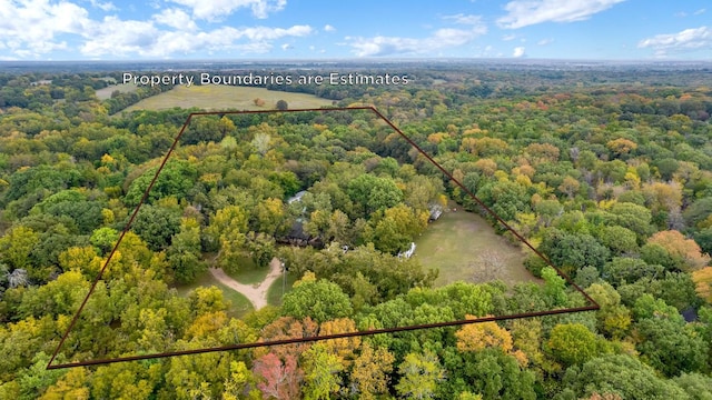 drone / aerial view featuring a wooded view