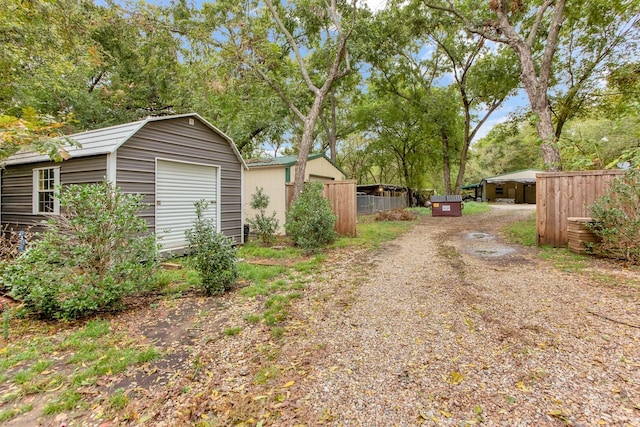 view of yard with an outbuilding, fence, and a storage unit