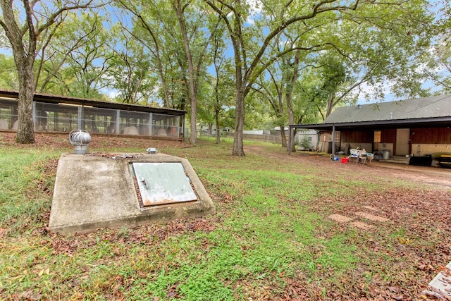 view of storm shelter with fence and a lawn