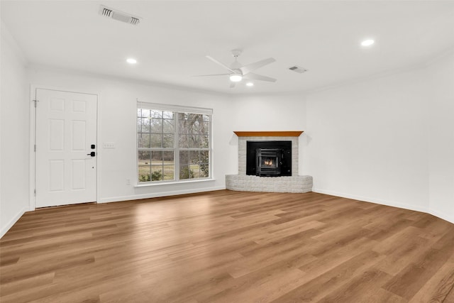 unfurnished living room featuring recessed lighting, a brick fireplace, visible vents, and wood finished floors