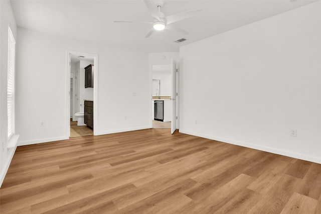 unfurnished bedroom with baseboards, light wood-style flooring, visible vents, and connected bathroom