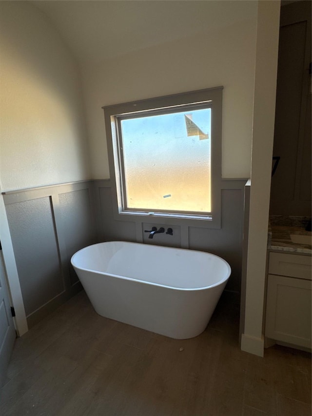 bathroom featuring hardwood / wood-style floors, vanity, and a washtub