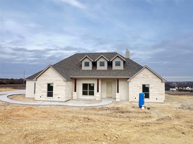 view of front of property with a chimney and a shingled roof