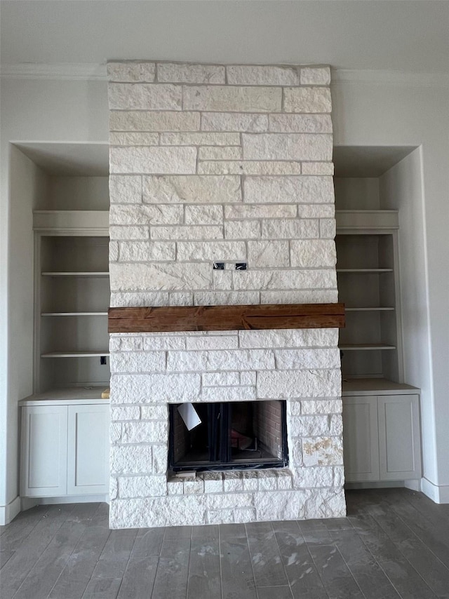 interior details featuring crown molding, built in features, a fireplace, and wood finished floors